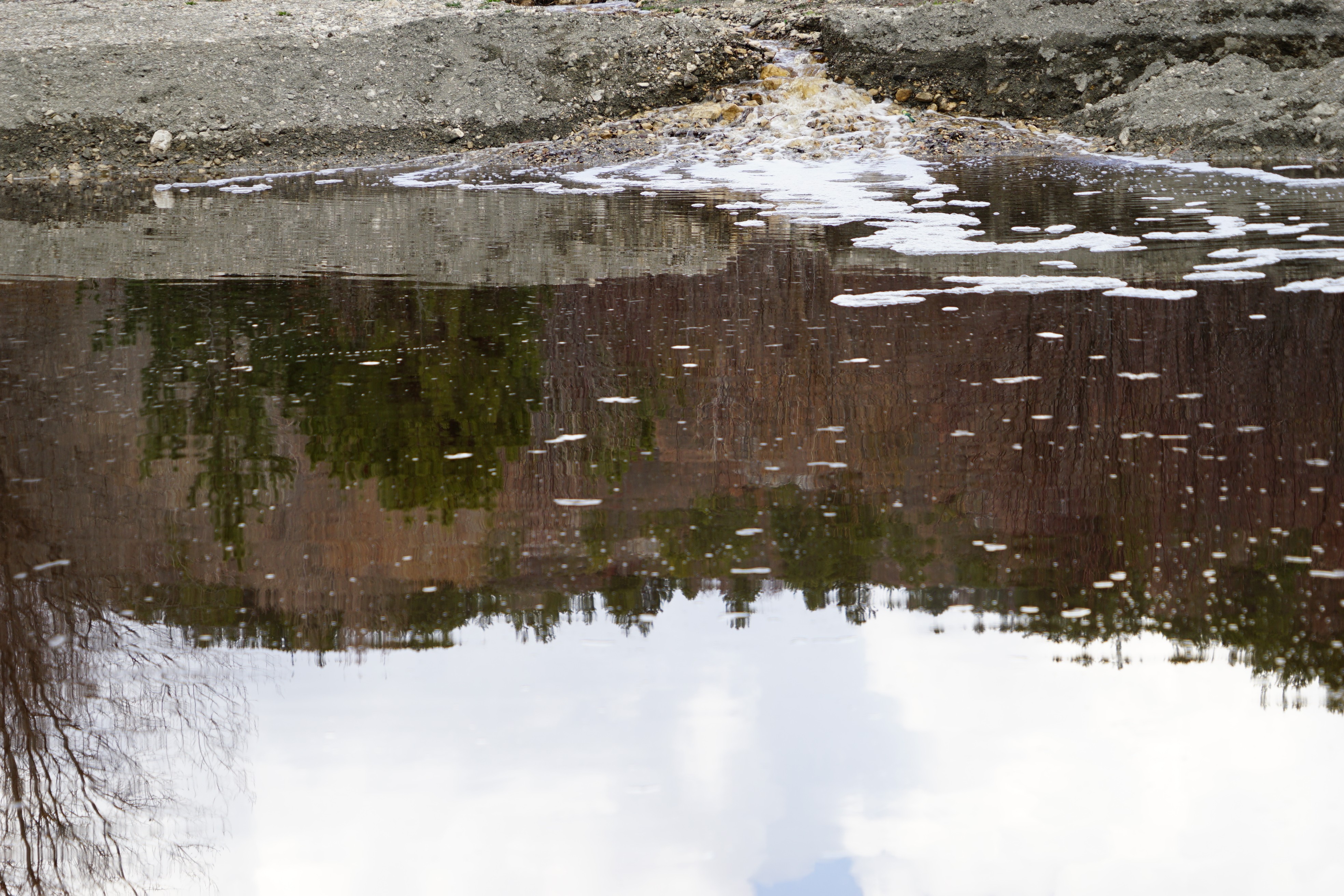 Bu derenin suyu kahverengi ve köpüklü akıyor