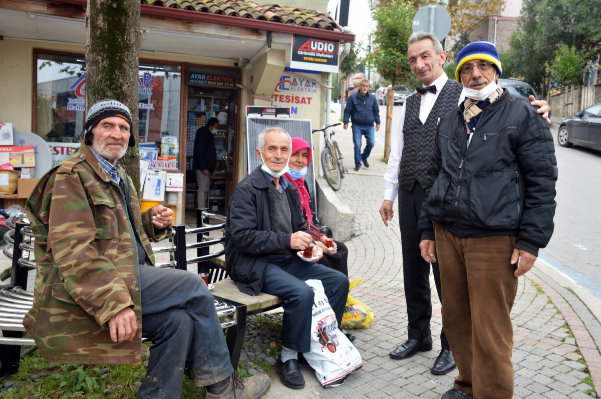 Takım elbisesiyle çay dağıttığını görenler şaşırıyor