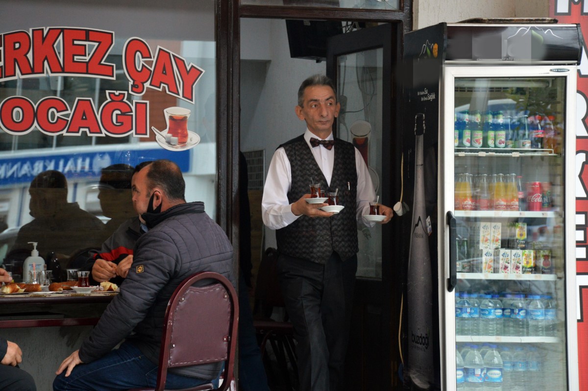 Takım elbisesiyle çay dağıttığını görenler şaşırıyor