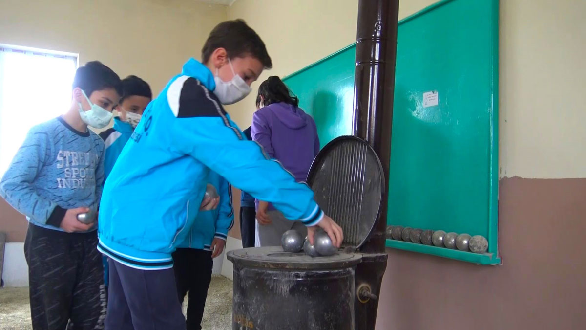 Soba üzerinde topları ısıtıp dağ köyünde bocce oynuyorlar